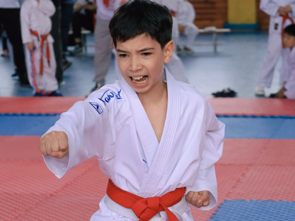 A young student in a karate uniform training at a dojo